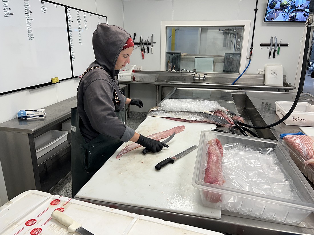 Heather Cook spends her workdays cutting whole fish to precise portions. On this day, she was working with mahi mahi. Southern Provisions in Jacksonville Beach prepares fish for distribution to Ben Groshell’s restaurant group, Southern Table Hospitality.