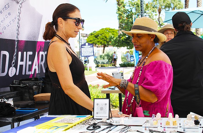 Patron Disha Webb tries on a ring crafted by artist Julia Bernadsky at last weekend's fine art festival on St. Armands Circle.
