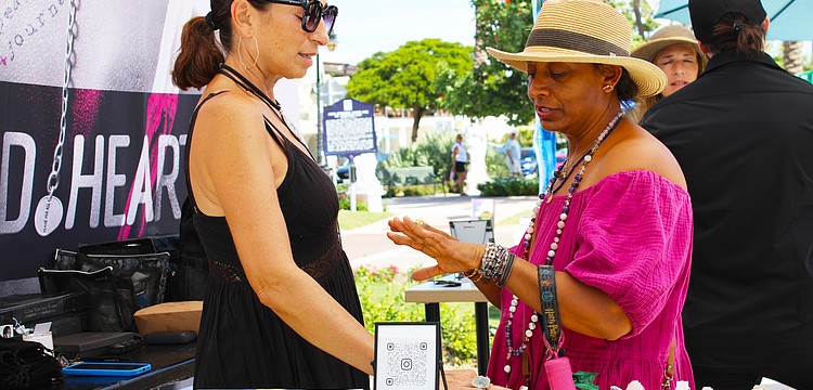 Patron Disha Webb tries on a ring crafted by artist Julia Bernadsky at last weekend's fine art festival on St. Armands Circle.