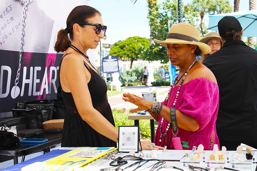 Patron Disha Webb tries on a ring crafted by artist Julia Bernadsky at last weekend's fine art festival on St. Armands Circle.