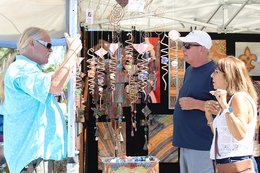 Artist Robert Boyce explains to customer Kirk Kempany how the physics of his 
