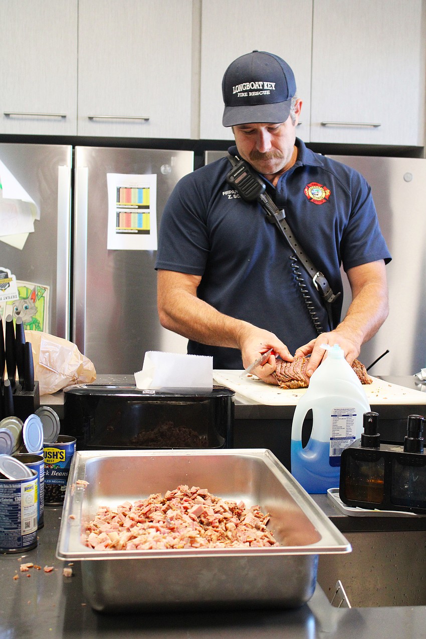 Longboat Key Fire Rescue firefighter/paramedic Zach Schield, who played a key role in formulating this year's chili recipe for the Morton's Cook-Off, preps brisket at the station on Oct. 18.