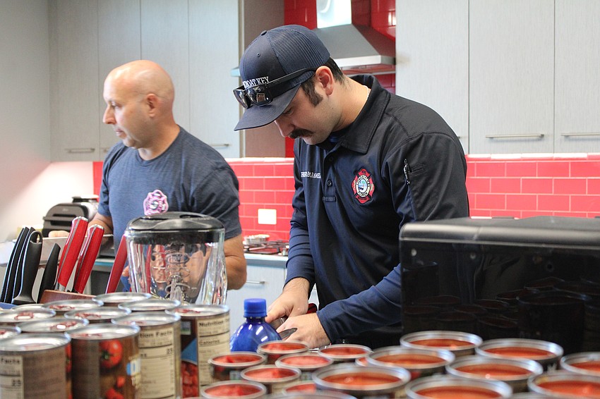 Longboat Fire Rescue firefighters/paramedics Tyler Brunton, right, and Andre Hoefer chop away as the team makes 30 gallons of chili ahead of competition day.