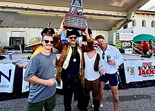 Trey Bowlin, Zach Schield, Tyler Brunton and Jamison Urch hoist the 25th Morton's Firehouse Chili Cook-Off trophy high as they take home first place for the Longboat Fire Rescue team.