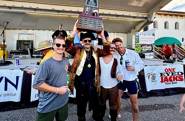 Trey Bowlin, Zach Schield, Tyler Brunton and Jamison Urch hoist the 25th Morton's Firehouse Chili Cook-Off trophy high as they take home first place for the Longboat Fire Rescue team.