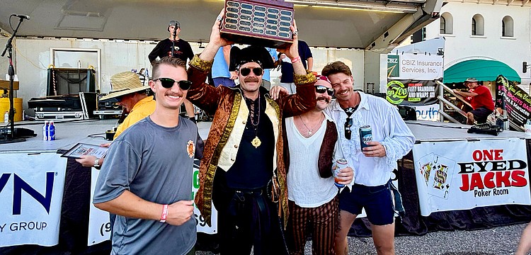 Trey Bowlin, Zach Schield, Tyler Brunton and Jamison Urch hoist the 25th Morton's Firehouse Chili Cook-Off trophy high as they take home first place for the Longboat Fire Rescue team.