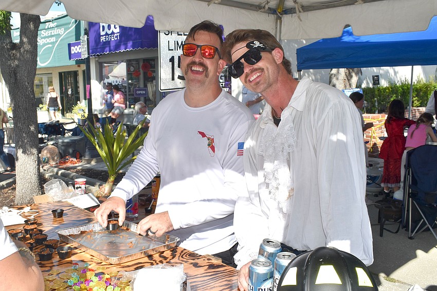 Aaron Maness and Jamison Urch serve up chili with a smile at the 25th Morton's Firehouse Chili Cook-Off. The Longboat team took first place this year.