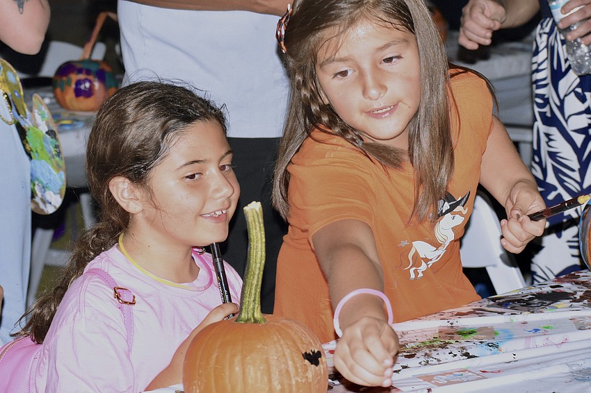 Beatrice Stathis, 8, and Lourdes Ceron, 8, decorate their pumpkins.