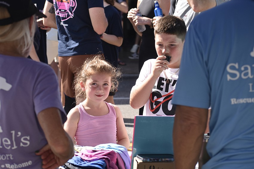 Emma Lacayo, 5, and her brother Aiden Lacayo, 7, talk with the people staffing the Satchel's Last Resort table.