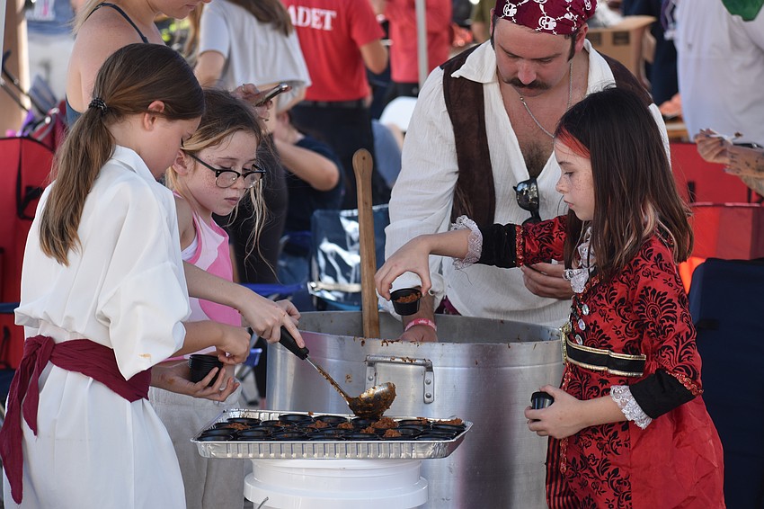 Ellie Bowlin, 9, Bindi Schield, 9, firefighter/paramedic Tyler Brunton and Tori Schield, 7, prepare chili at the Longboat Key Fire Rescue's tent.