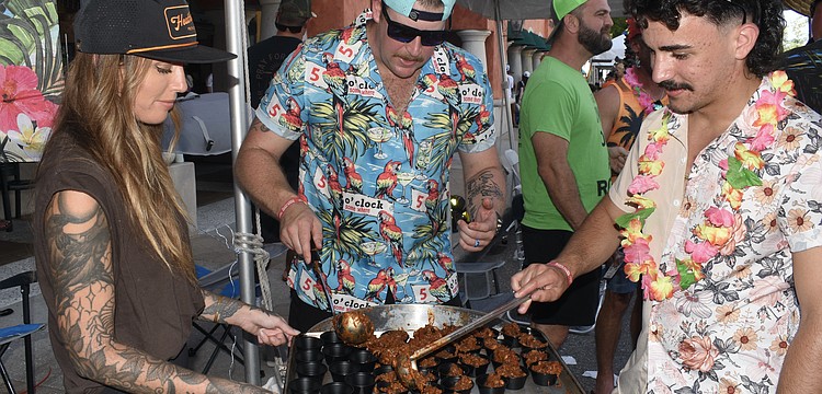 Tara Piedra, and Ariel Betancourt and Michael Matheis of Station 9, prepare chili.