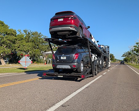 A car carrier sits in the median of Gulf of Mexico Drive Tuesday, Oct. 14. Many seasonal residents fly down and have their cars shipped on carriers to Longboat Key, and the return of the car transporters has become known as one of the first signs of the more busy winter season.