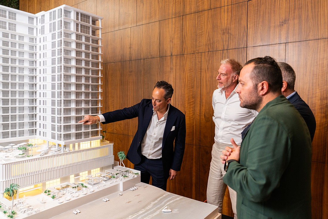 Moises Agami, CEO of Valor Real Estate Development, Marek Reichman, executive vice president and chief creative officer of Aston Martin, Stefano Saporetti, director of brand diversification at Aston Martin and 
Leon Salame, chief operating officer at Grupo Bosque Real look at an architect’s model, of the Aston Martin Residences Daytona Beach Shores.