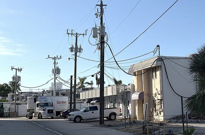 Overhead utility lines behind commercial buildings on St. Armands Circle.