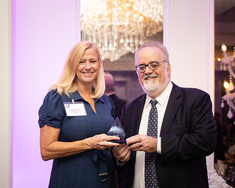 Carrie Baird, chief executive officer of Flagler Cares, receives the Above and Beyond Award from Jim Saunders, executive editor of the News Service of Florida. Courtesy photo by Eric Martin.