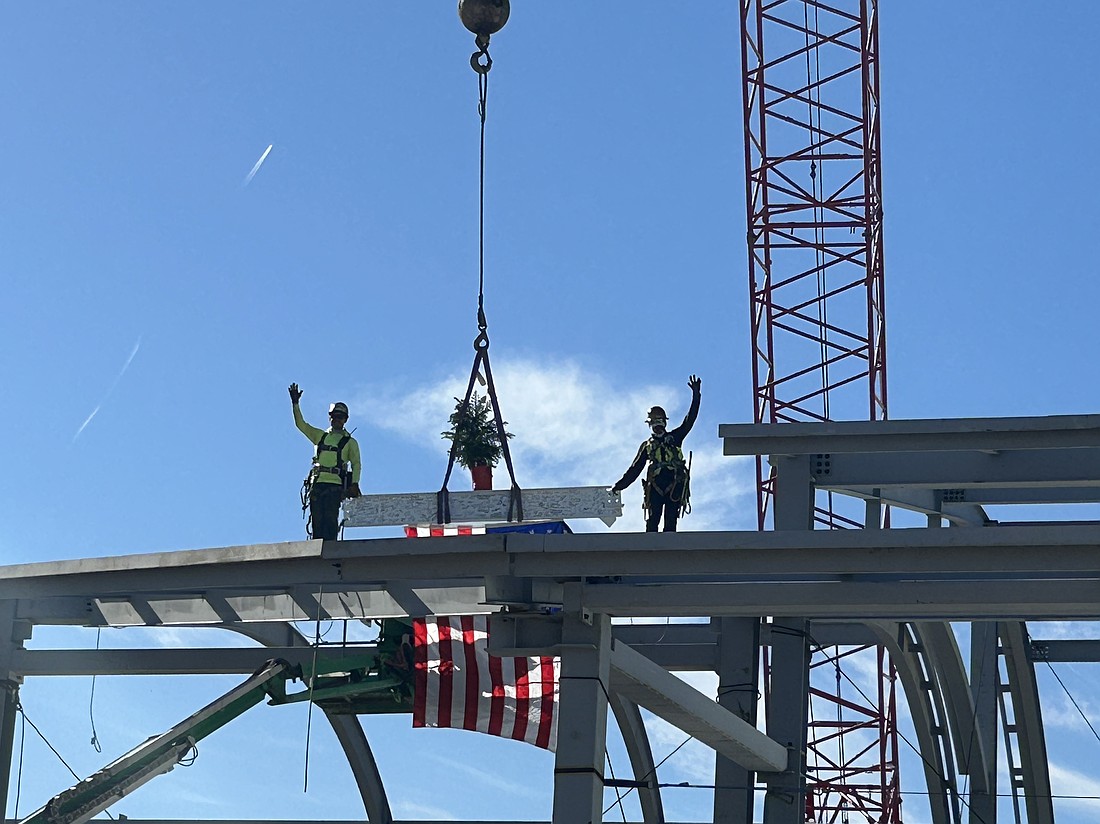 The final beam is placed by workers at the topping-out ceremony for the new Concourse B at Jacksonville International Airport. It is customary to install the final beam with a pine tree for luck, a Scandinavian tradition.