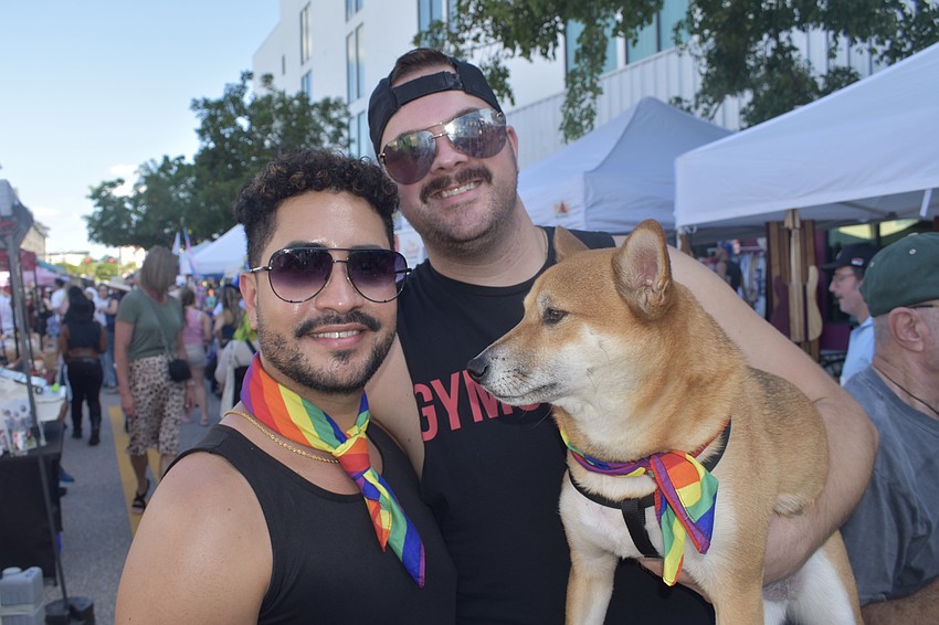 Charles Herwig, his partner Ty Knightingale and their dog Bronco walk the vendor market.