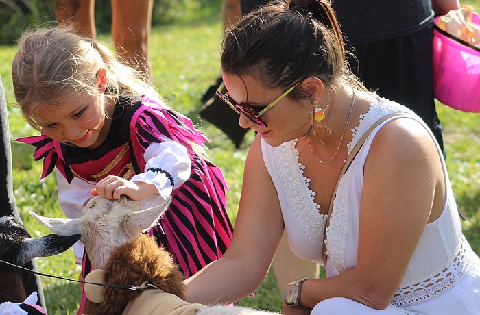 Lakewood Ranch 5-year-old Cora Forrester and her mom Cassie Campbell give some love to Banjo the goat from Blissful Goat Yoga during East Manatee Fire Rescue's Trunk or Treat Oct. 25.