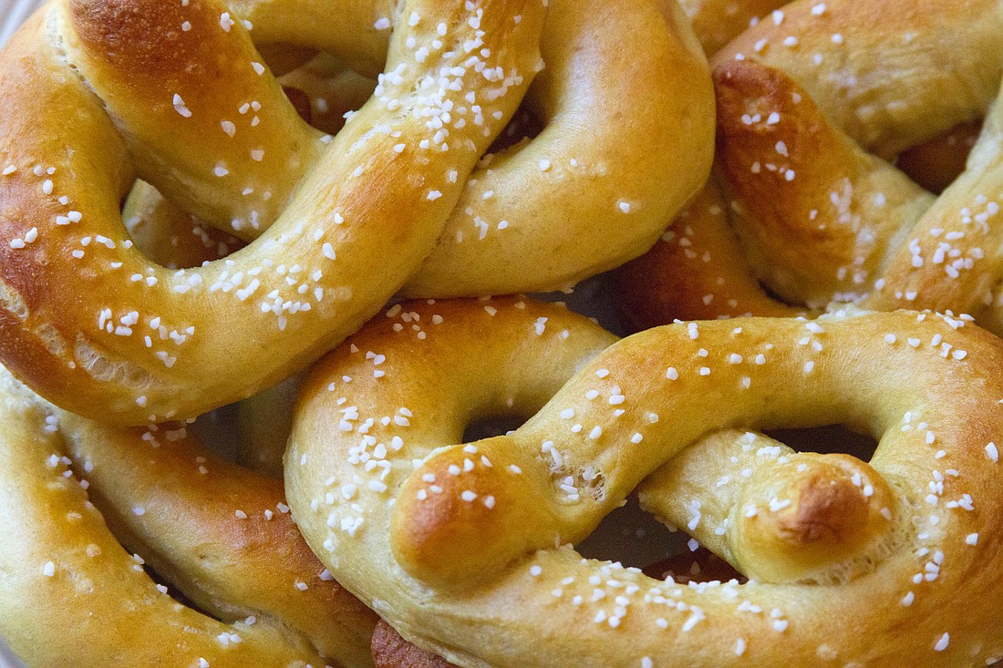 Close up of a palte of homemade, golden brown, Philadelphia soft pretzels.