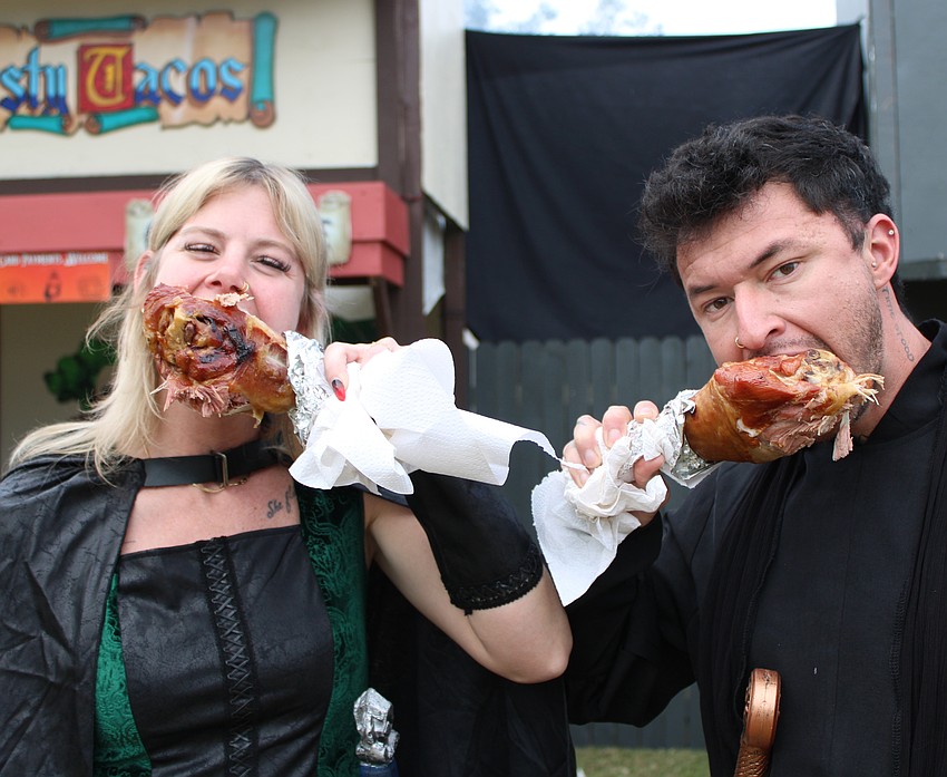 Sarasota's April Held and Venice's Alan Saldivar enjoy turkey legs at Sarasota Medieval Fair. Saldivar describes it as delicious, juicy, tender and mouth watering.