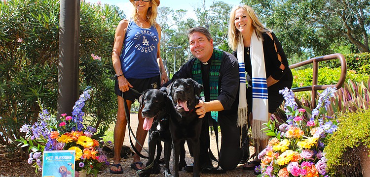 Diane Weisman brings her black Labrador retrievers to join an interfaith pet blessing from Rev. David Marshall of All Angels by the Sea Episcopal Church and Rabbi Jessica Spitalnic Mates of Temple Beth Israel of Longboat Key on Oct. 26.