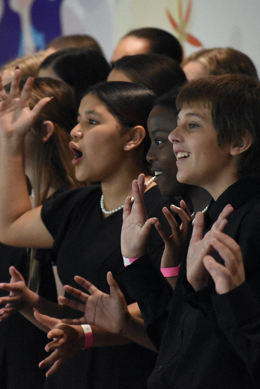 Seventh graders Janelly Mejia, Abigail Denize, and Walter Zacharko, of Sarasota Middle School, perform with the Sarasota Middle School Joyful Voices Choir.
