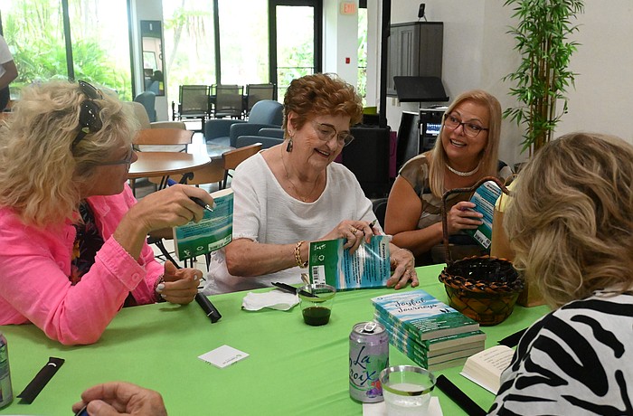 Valerie DiLorenzo, Janice Boring and Silvia Flores perform a book signing.