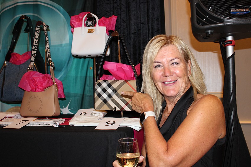 Heidi Rapp points at the Burberry purse she hopes to win during Designer Bag Bingo at the Grove Nov. 6 in Lakewood Ranch.