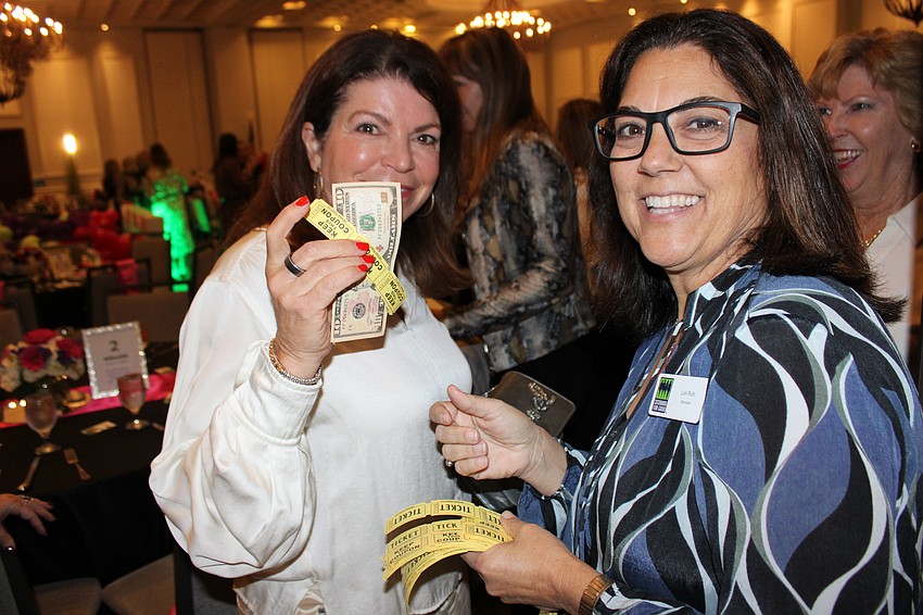 Sisterhood for Good's Debbie Urban buys raffle tickets from fellow Sister Lori Ruth.