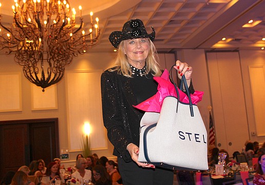 Sisterhood for Good's Glo Reber not only shows off the first prize of the night, a $1,200 Stella McCartney tote, but her numbers were then called and she won the bag.