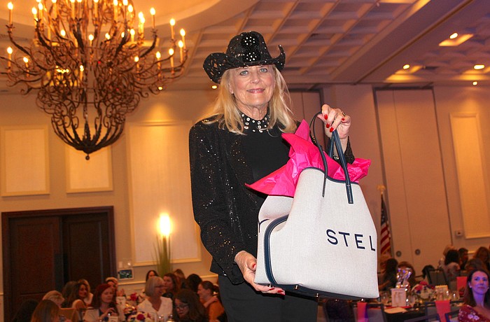 Sisterhood for Good's Glo Reber not only shows off the first prize of the night, a $1,200 Stella McCartney tote, but her numbers were then called and she won the bag.