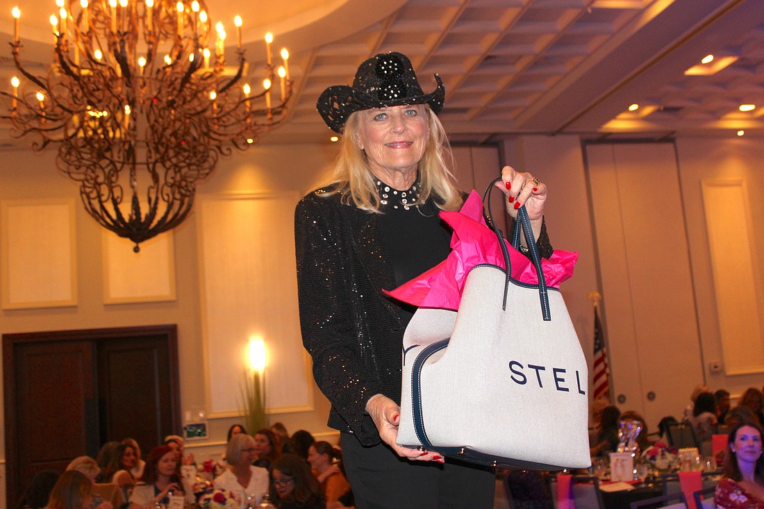 Sisterhood for Good's Glo Reber not only shows off the first prize of the night, a $1,200 Stella McCartney tote, but her numbers were then called and she won the bag.
