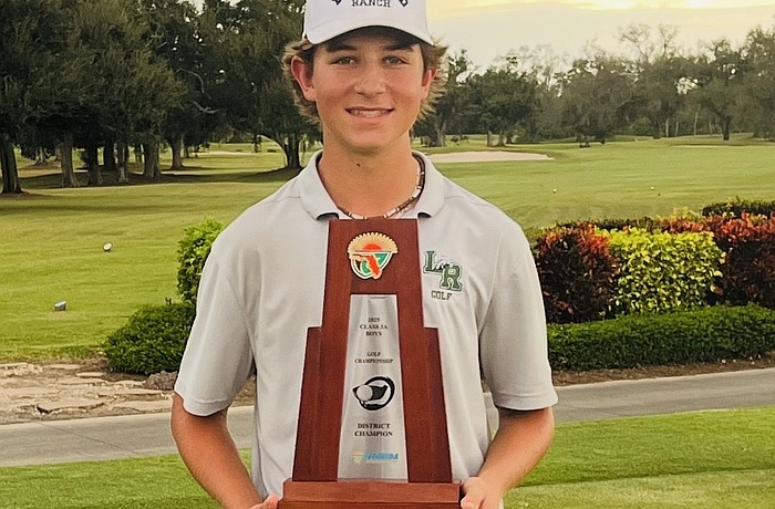 Donovan Plakyda poses for a photo on Oct. 27 with the FHSAA Class 3A District 11 trophy. The junior has dropped 14 strokes in an 18-hole format since his freshman season.