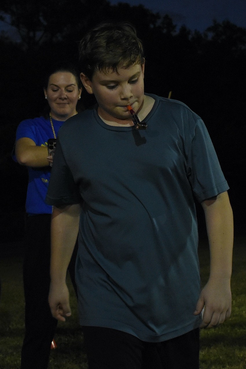Teacher Brianna McClenathen times  Christian Davis, 11, as he does the cakewalk.