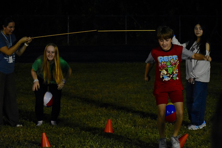 Teacher Danielle Young, Arianna Howard, 12, Landyn Howard, 10, and Christyl Aira Villafuerte enjoy a race in which participants waddle like turkeys.
