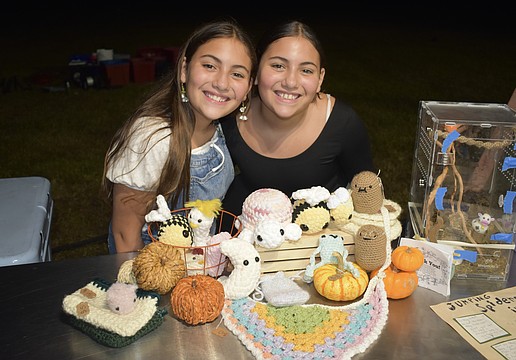 Alyssa Rico and her twin Andrea Rico, 11, stand beside crochet items that Andrea made.