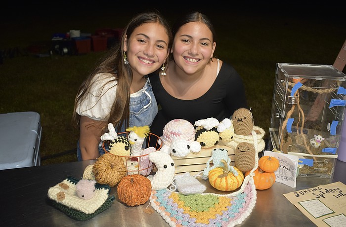 Alyssa Rico and her twin Andrea Rico, 11, stand beside crochet items that Andrea made.