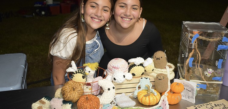 Alyssa Rico and her twin Andrea Rico, 11, stand beside crochet items that Andrea made.