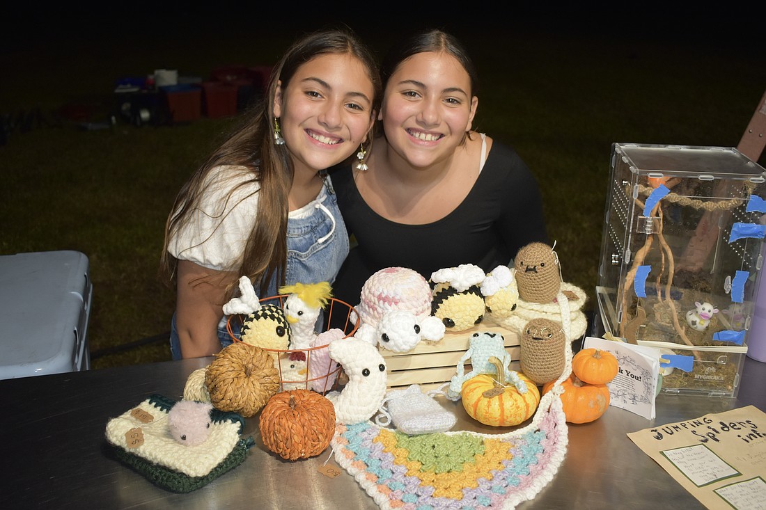Alyssa Rico and her twin Andrea Rico, 11, stand beside crochet items that Andrea made.