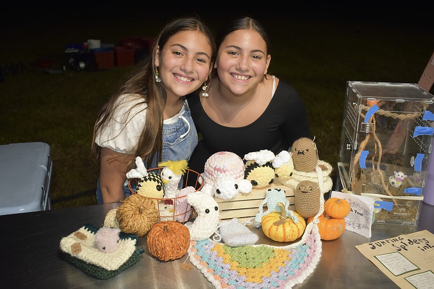 Alyssa Rico and her twin Andrea Rico, 11, stand beside crochet items that Andrea made.