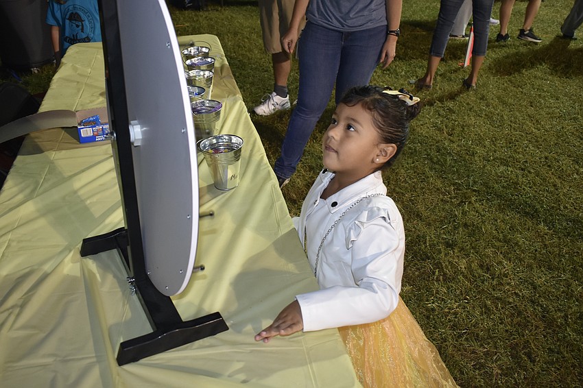 Jade Vaquero, 4, watches a prize wheel after giving it a spin.