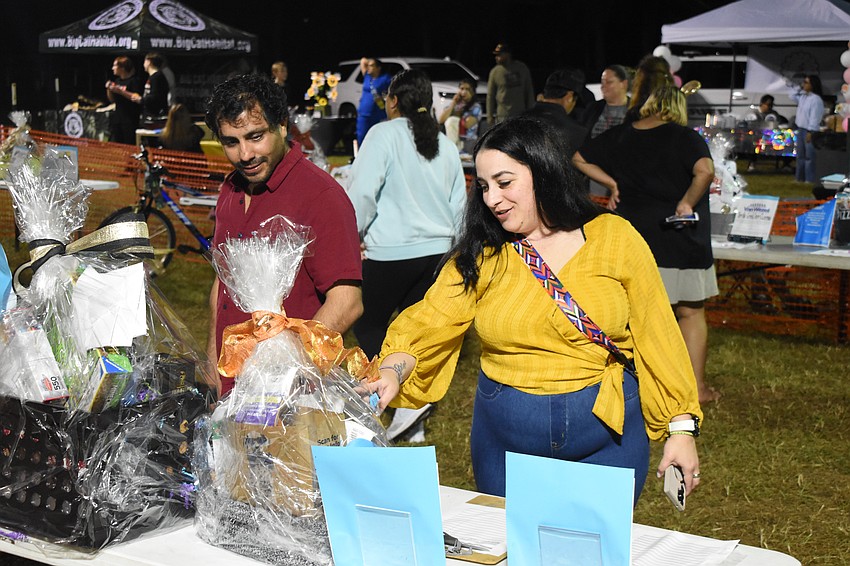 Miguel Hurtado and his wife Dulze Hurtado look at the prize baskets.