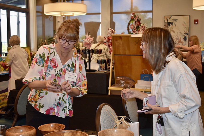 Waterlefe's Betty Hruska sells a walnut bowl to Lakewood Ranch's Jill Grove. The wood was salvaged after Hurricane Helene.