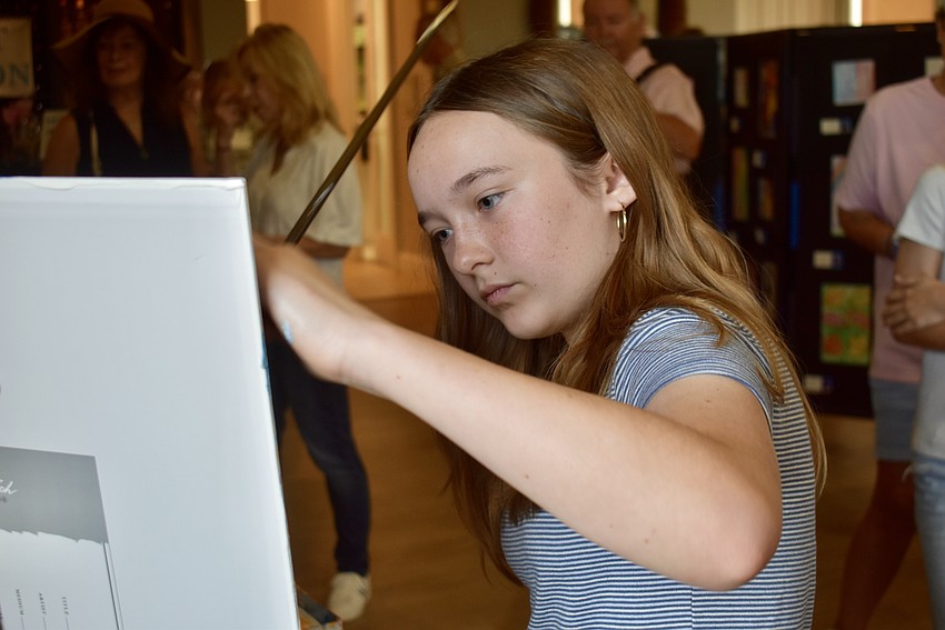 Seventh grader Madelyn Sutton adds to a collaborative painting.