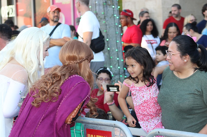 Bradenton 5-year-old Lilith Joven and her mom, Karmela Joven, visit with Anna and Elsa at the Santa's Grand Arrival Parade.