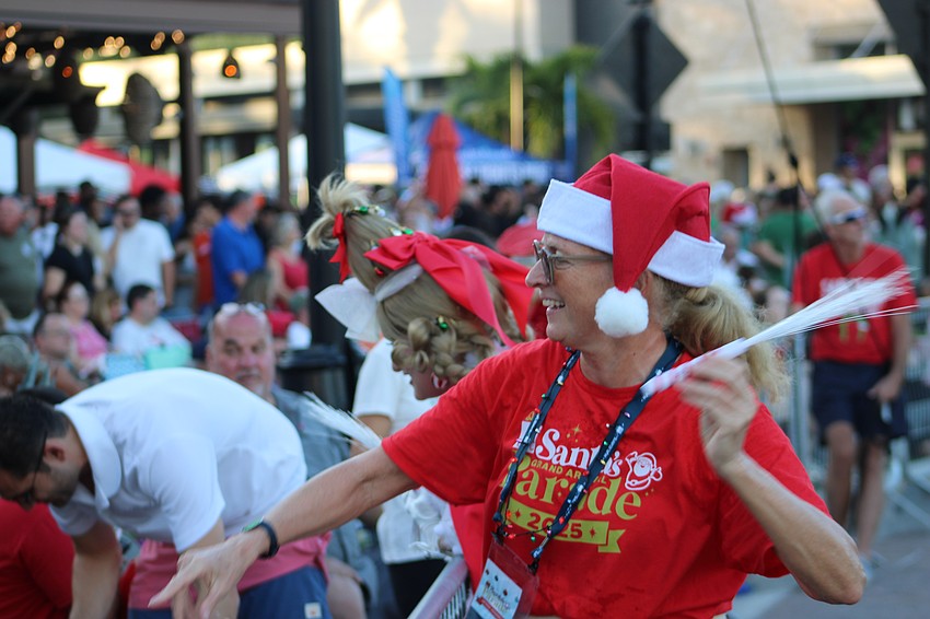 Lakewood Ranch parade volunteer Rosemary Stack gets into her job of throwing glow sticks into the crowd.