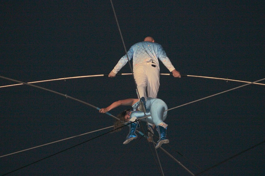 Nik Wallenda completes the criss cross stunt by stepping over his sister Lijana Wallenda on the wire high above the Santa's Grand Arrival Parade grounds.