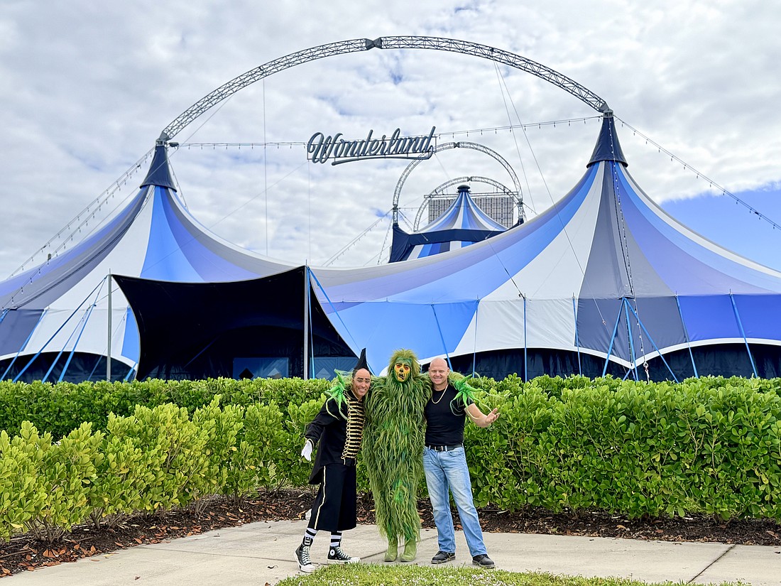 Daredevil clown Johnny Rockett, the Grinch and superstar aerialist Nik Wallenda pose in front of Wonderland's new tent near UTC.