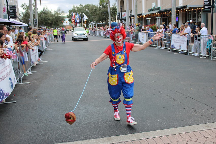It's hard enough to walk a dog during a parade, but clown Betty Palsgrove has to walk her hot dog down Lakewood Main Street.