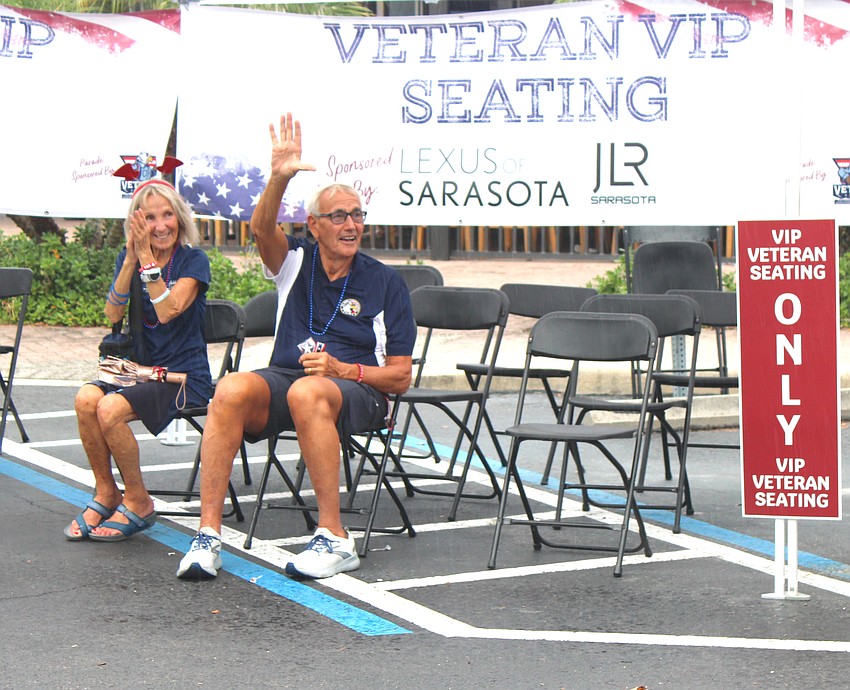 Del Webb's Becky and Ralph Ciujan make use of the veterans' seating area just before the rain begins to fall at the end of the Tribute to Heroes Parade.